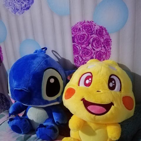 A QooBee plushy sitting next to a blue plush friend